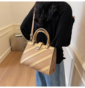 Dettaglio della borsa tote kaki a righe con tracolla regolabile e chiusura in metallo