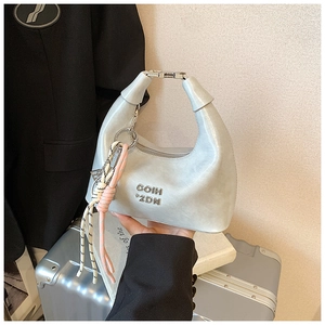 Détail du sac à main en cuir bleu clair avec lettres COIH 2DN et breloque tressée