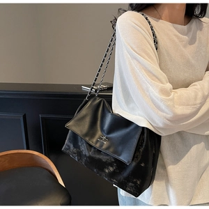 Close-up of vintage black tote bag featuring matte PU leather and silver chain strap