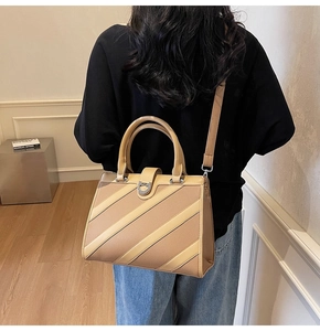 Dettaglio di una borsa tote in pelle bicolore con fibbia a D argento su modella