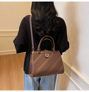 Borsa tote in pelle litchi marrone con fibbia a U argento indossata da una modella