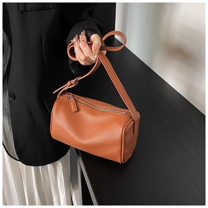 Détail du sac cylindre marron avec texture litchi et fermeture éclair argentée