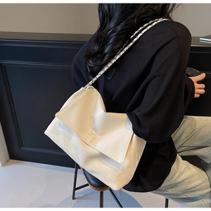 Detail of cream chain shoulder bag with star metal logo and pleated flap texture