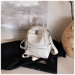 Close-up of off-white lychee grain PU backpack showing zipper details and top handle
