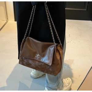 Detail of vintage brown leather tote bag with silver chain strap and star logo embossing