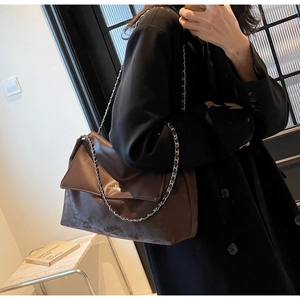 Brown leather tote bag featuring a large flap cover and silver metal chain strap
