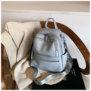Close-up of light blue lychee pattern leather backpack with multiple zipper pockets