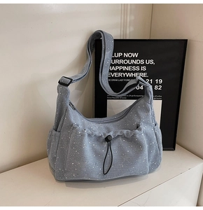 Detail of light blue corduroy crossbody bag featuring a glittery finish and drawstring pocket