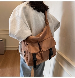 Detail of caramel nylon tote bag showing double front pockets and adjustable shoulder strap