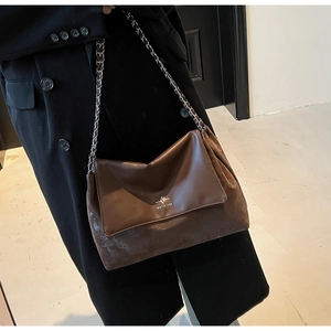 Detail of dark brown leather and suede patchwork shoulder bag with chain strap