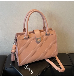 Dettaglio borsa in pelle rosa con fibbia a U in cristallo e trama diagonale