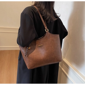 Detailansicht der braunen Leder-Shopper mit Vintage-Textur und Metall-Anhänger-Detail