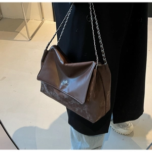 Detail of vintage dark brown tote bag with retro textured finish and silver chain strap