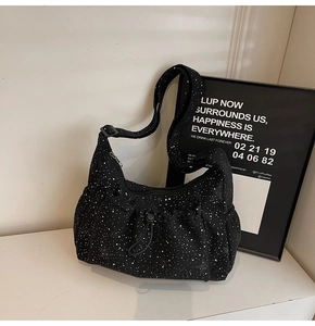 Close-up of black corduroy tote with white star pattern and drawstring front pocket detail