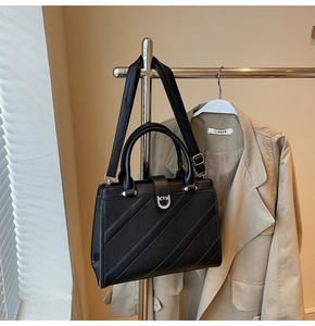 Dettaglio borsa a mano in pelle martellata nera con fibbia a U decorata con strass