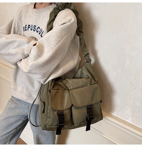 Detail of army green nylon tote bag featuring ruched cloud strap and utility buckle pockets