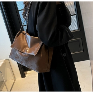 Detail of vintage brown leather shoulder bag with chain strap and printed logo on flap
