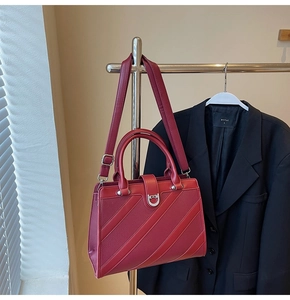 Dettaglio borsa a mano rosso scuro in pelle testurizzata con fibbia in metallo argento