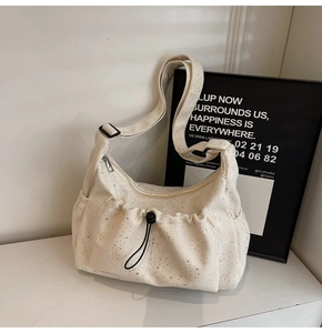 Detail of off-white corduroy tote bag showing sequin texture and drawstring pocket