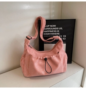 Detail of pink corduroy crossbody bag featuring silver sequins and drawstring pocket