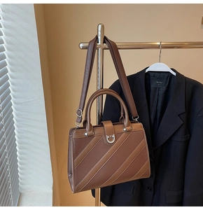 Dettaglio della borsa tote in pelle sintetica marrone con cuciture diagonali e fibbia a ferro