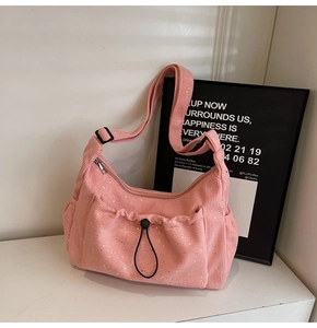 Detailed macro view of pink corduroy fabric with shimmering silver accents on the shoulder bag