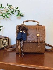 Vintage brown leather backpack with crocodile pattern flap and cute bear pendant charm