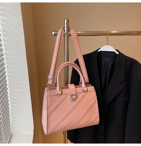 Dettaglio della borsa rosa in pelle con fibbia a ferro di cavallo e tracolla regolabile