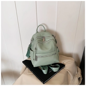Close-up of mint green litchi texture backpack with silver hardware and zipper details