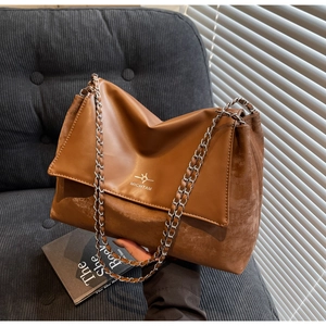 Detail of vintage brown tote bag with dual texture patchwork and metallic chain strap