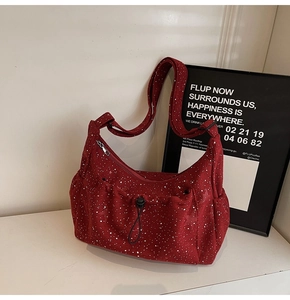 Detailed view of burgundy corduroy crossbody bag with white polka dots and drawstring pocket
