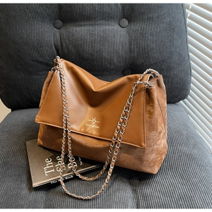 Detail of vintage brown chain shoulder bag on corduroy surface with soft shadow