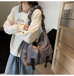 Detail of silver-grey nylon tote bag with buckle pockets and ruched wide shoulder strap