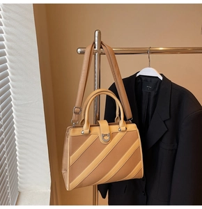 Dettaglio della borsa tote in pelle marrone con motivo patchwork e fibbia metallica