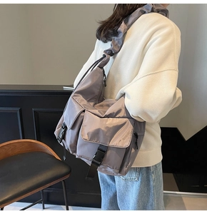 Detail of smoke grey nylon tote bag featuring cargo pockets and ruffled cloud shoulder strap