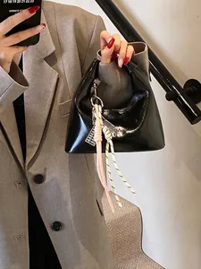 Sac à main croissant noir brillant avec breloque nœud tressé et pendentif boulier