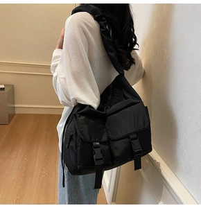 Detail of black waterproof nylon tote bag featuring cargo pockets and stylish ruched strap