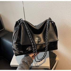 Detailed shot of large black chain tote bag featuring vintage PU leather and logo