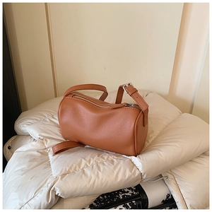 Détail du sac cylindre marron avec texture grainée litchi et fermeture éclair en métal