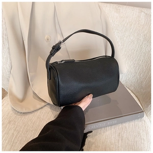 Vue détaillée du sac polochon en cuir noir à motif litchi avec une boucle argentée
