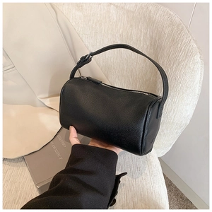 Détail du sac boston en cuir grainé noir avec zip argenté et bandoulière réglable