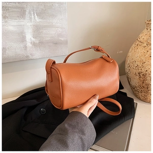 Détail du sac cylindre en cuir grainé orange avec fermeture éclair et bandoulière