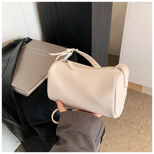 Détail du sac polochon en cuir crème avec bandoulière réglable et boucle métallique