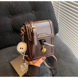 Brown vintage faux leather crossbody phone bag with plush charm and gold hardware