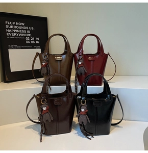 Detailed view of glossy bucket bags in four colors with bear charms and woven tassels