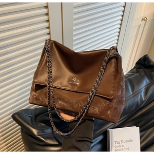 Close-up of brown textured patchwork bag with chain strap and MICHTAM logo detail