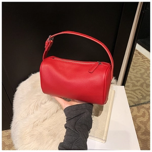 Détail du sac à main cylindrique en cuir grainé rouge avec fermeture éclair et poignée