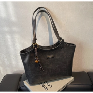 Detail der dunkelgrauen Shopper-Tasche mit Vintage-PU-Textur und goldenem Anhänger