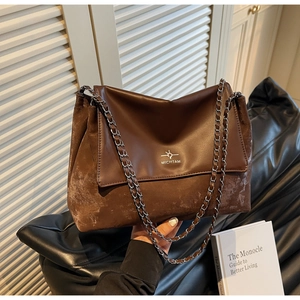 Detail view of the vintage brown patchwork leather flap bag with metal chain strap