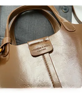 Detail of brown leather handbag featuring embossed lettering and fine vintage texture
